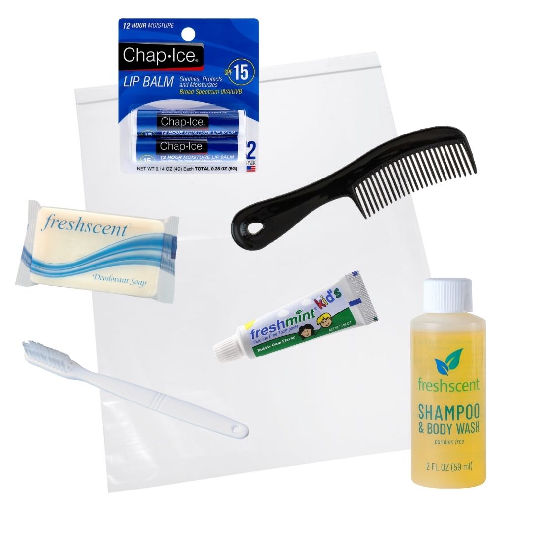 A hygiene kit including a comb, soap, shampoo, toothbrush, toothpaste, lip balm, and a clear plastic bag.